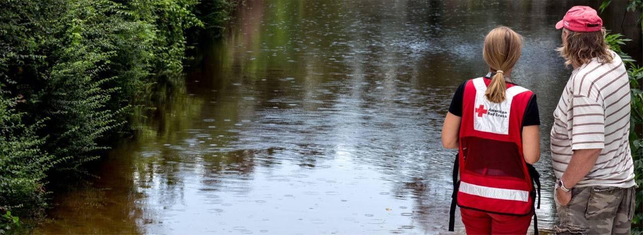 man looking at flood with volunteer