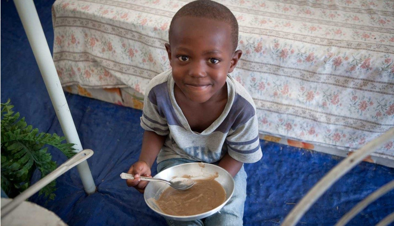 Boy in Haiti holds meal