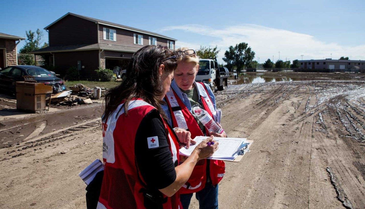 Two Red Cross volunteers looking at clipboard