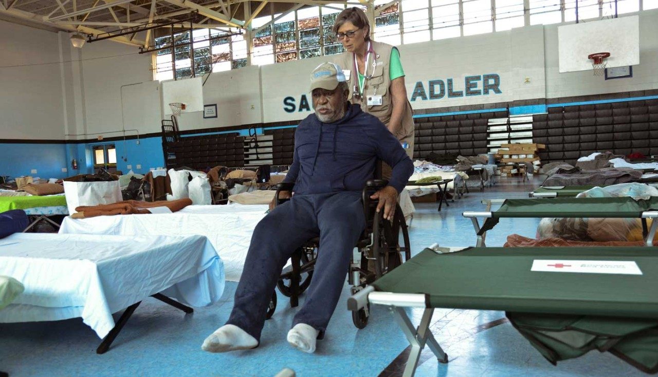 Red Cross volunteer helping man in wheelchair