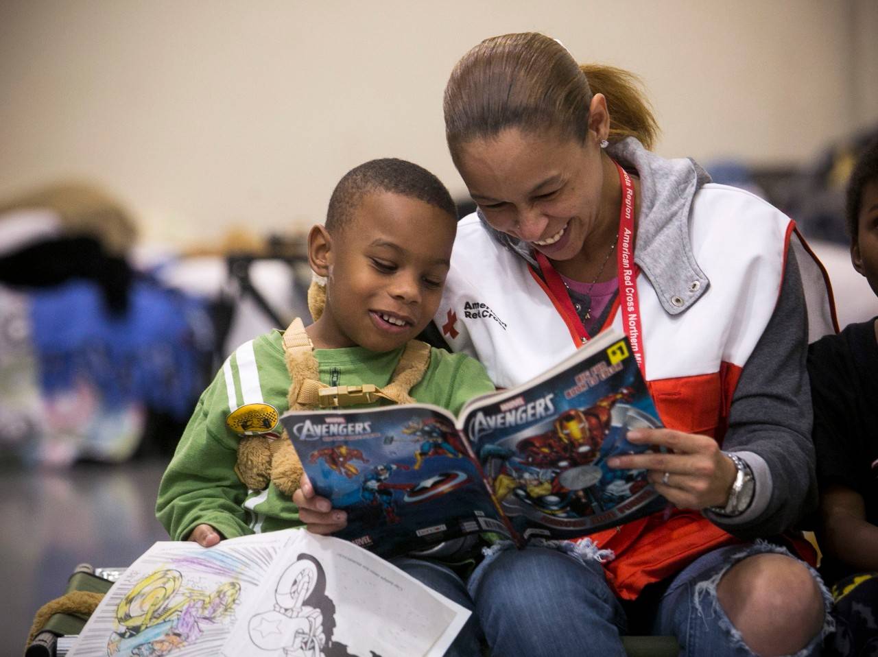 January 3, 2016 -- Garland, Texas -- Red Cross shelter at the Gale Fields Recreation Center.  Red Cross volunteer Misty Manglona reads to Jeremiah Moore. Photos by Dennis Drenner for the American Red Cross. , Woman reading to boy in shelter