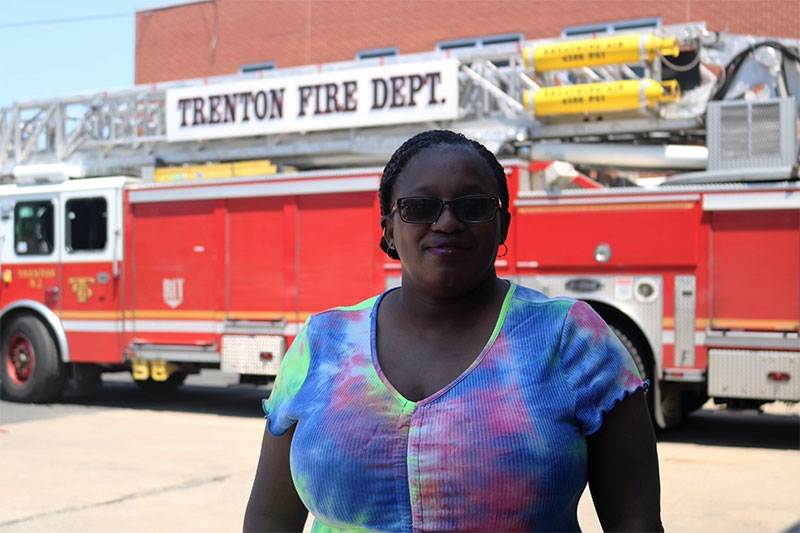 Woman wearing sun glasses with fire engine in the background