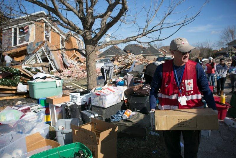 ERV crew James and Becky Carmichael deliver clean up supplies (tarps, shovels, gloves, etc) to families in Rowlett, TX whose homes were damaged by the recent tornadoes near Dallas.   James delivers some tarps.  Photos by Dennis Drenner for the American Red Cross.