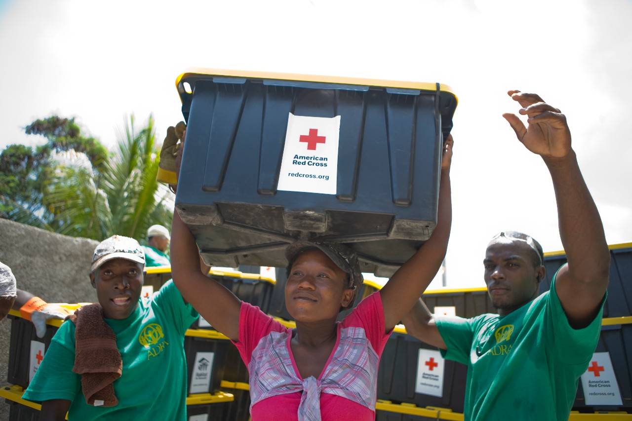 Shelter workers hold create of supplies in Haiti