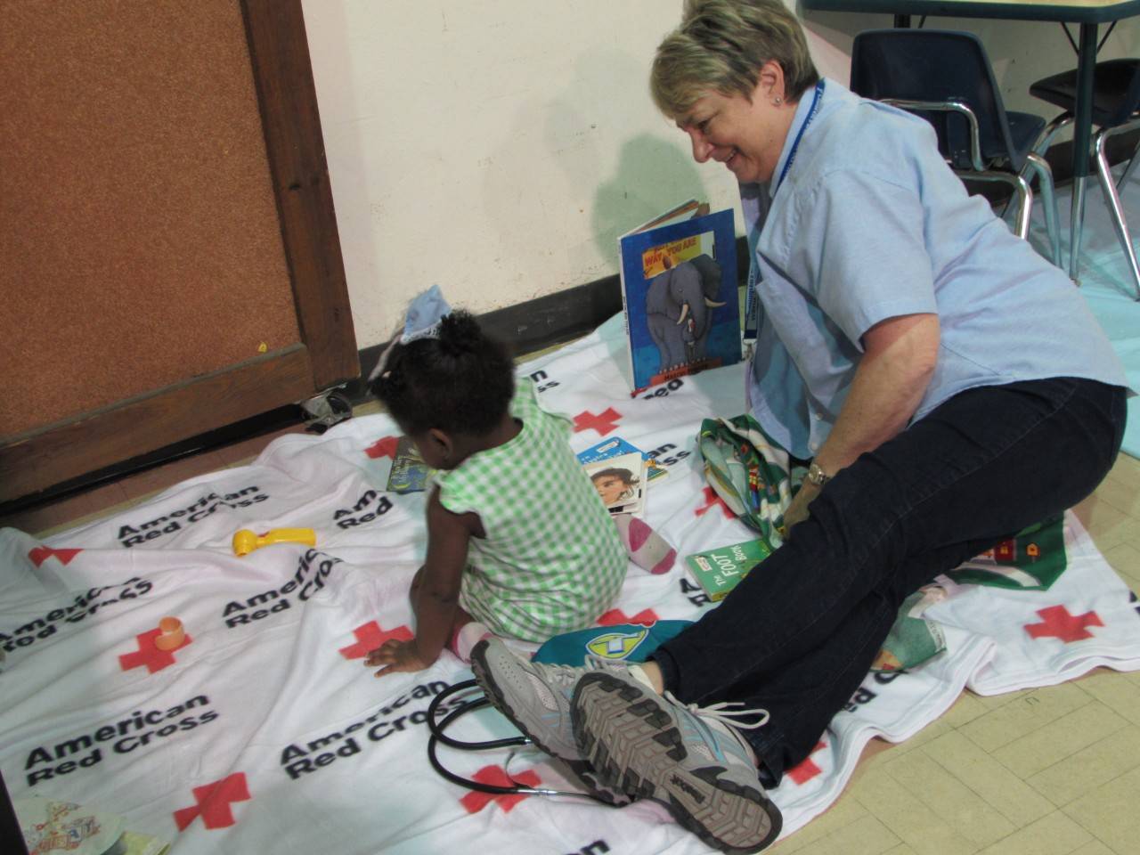 Children’s Disaster Services volunteer Connie Rutt plays with 17 month-old Paige at a Red Cross shelter in Richmond, TX. Red Cross photo by Mallory Scheve