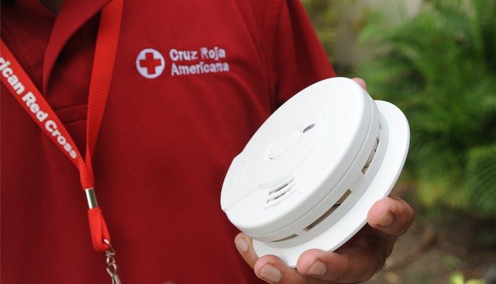 Red Cross volunteer holding smoke alarm