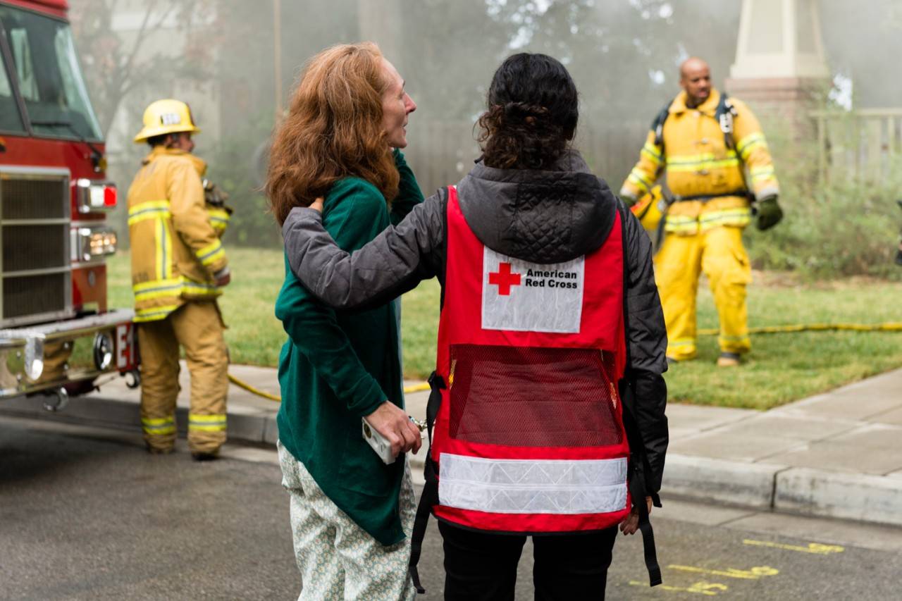 Volunteer comforts woman at home fire