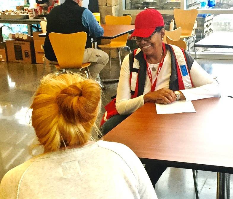 Gatlinburg, Tennessee, December 8, 2016 -- American Red Cross volunteer Karen Bussell of Knoxville talks to a resident at the Red Cross shelter in Gatlinburg after a wildfire swept through the area. Karen is a mental health counselor who talks to those affected by disaster to help them cope with what they have been through.  Photo by Carl Manning for the American Red Cross