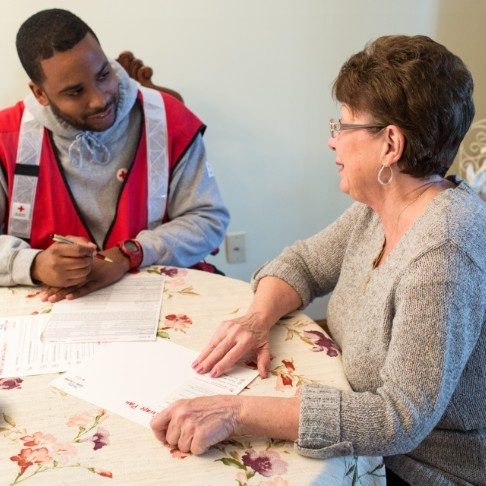 A Red Cross volunteer explaining how to get started with their application.