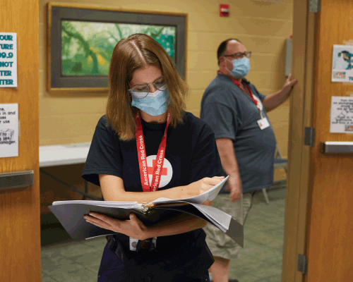 red cross disaster finance volunteer holding a binder.