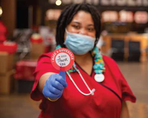 A Disaster Health Services team member holding up a thank you sticker.