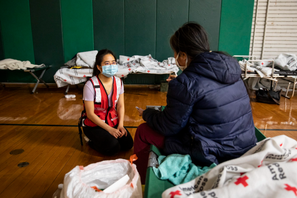 American Red Cross volunteer Audrey Nguyen speaks with a client who is staying at a Red Cross shelter.