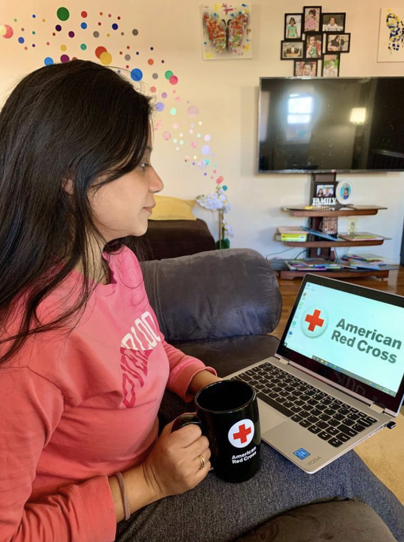 A Red Cross volunteer looking at her laptop.