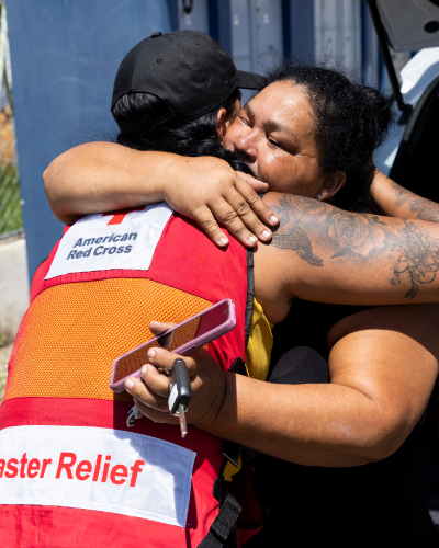 Red Cross volunteer hugging a woman affected by Hurricane Ian.