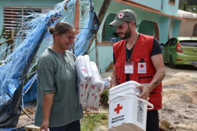 Red Cross volunteers distribute water, food and other basic necessities to families affected by Hurricane Maria.