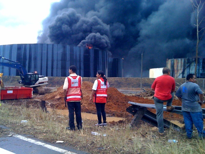 Fotografía de miembros de la Cruz Roja y civiles durante el fuego en el complejo de tanques de combustibles Capeco