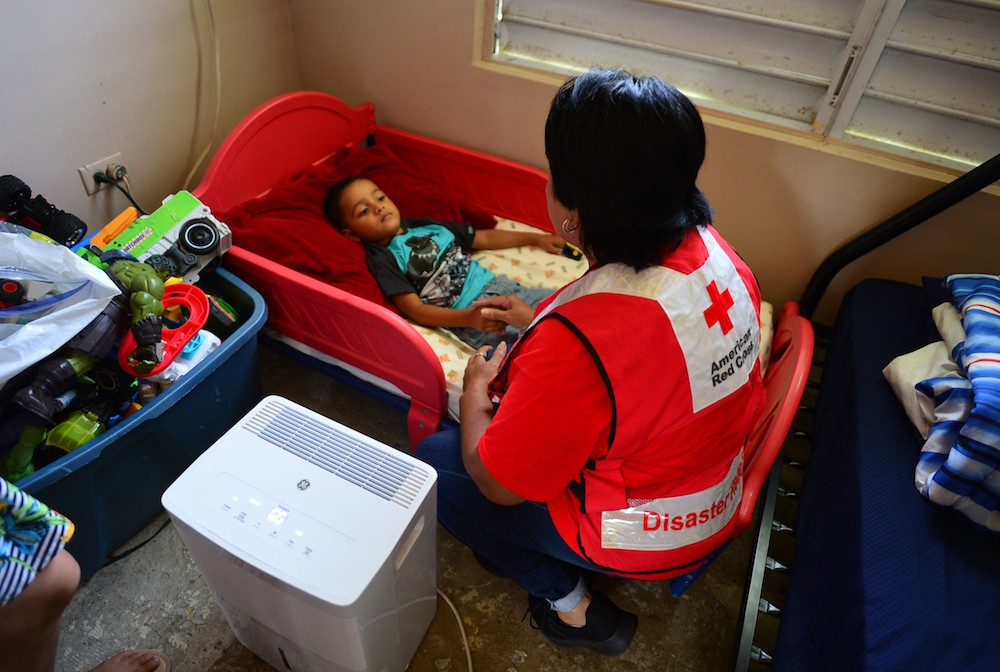 Fotografía de una voluntaria de la Cruz Roja con Jaycob, de 4 años, quien recibió un marcapasos.