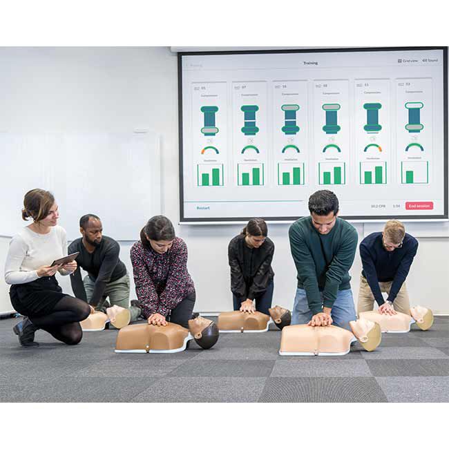 A CPR Instructor Monitoring Students Training on Little Anne QCPR Enabled Adult CPR Manikins with the QCPR App.