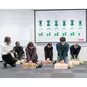A CPR Instructor Monitoring Students Training on Little Anne QCPR Enabled Adult CPR Manikins with the QCPR App.