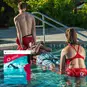 Two lifeguards rescuing someone from a pool, and a picture of the cover of the Red Cross Lifeguarding Manual.