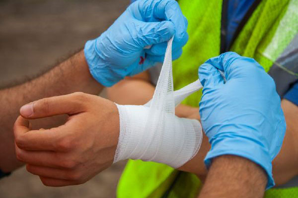A construction worker bandages an injured coworker in California.