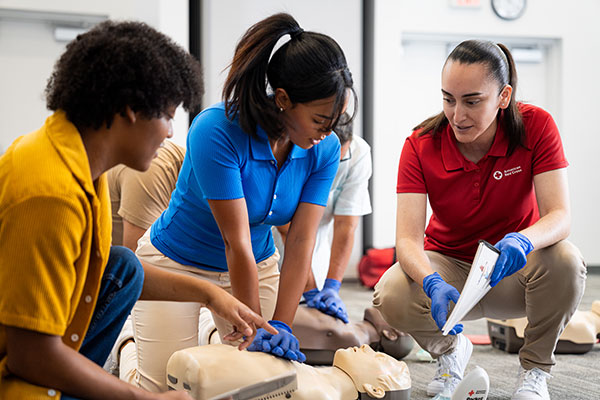 A woman practices performing CPR in Middletown, New York while another student watches and the instructor monitors.
