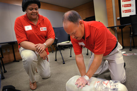 Red Cross person training a CPR class